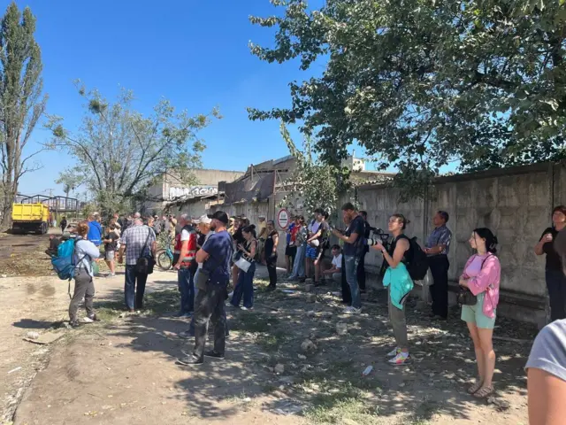 Люди біля будинку чекають на інформацію про своїх рідних