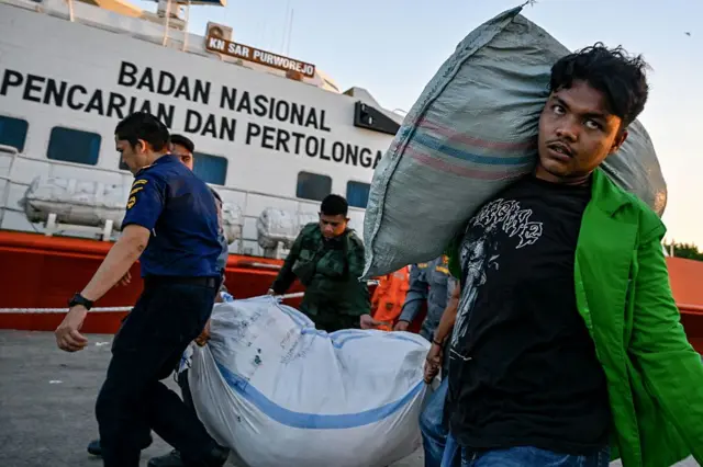 Relawan membantu mengangkat bantuan untuk korban bencana di Banda Aceh pada 1 Desember 2025.