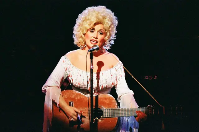 Dolly Parton con una guitarra en la década de 1970