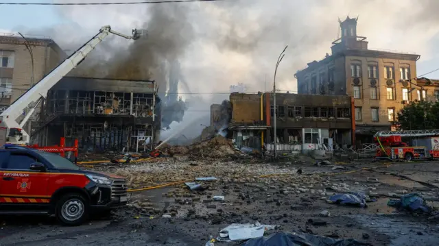 Porušene zgrade i vatrogasne ekipe koje gase požar