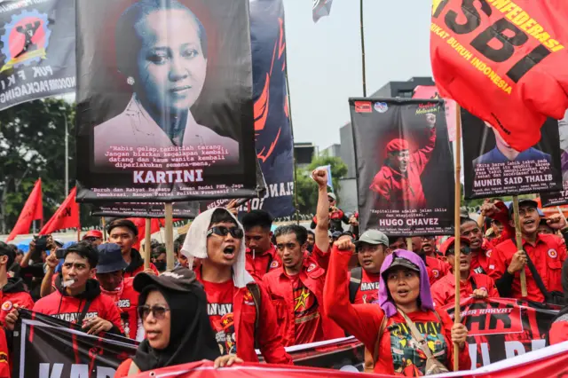Pengunjuk rasa membawa poster saat aksi memperingati Hari Buruh Internasional di depan Gedung DPR, Senayan, Jakarta, Kamis (1/5/2025).