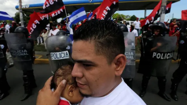 La policía antidisturbios impide que simpatizantes del FSLN se enfrenten a manifestantes contra el gobierno del presidente nicaragüense Daniel Ortega, durante una marcha en Managua, el 9 de septiembre de 2018.