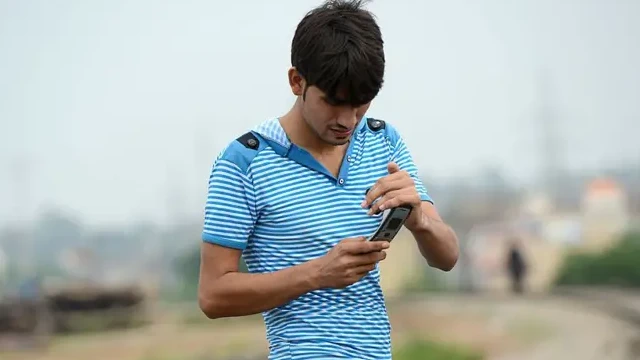 پاکستان میں ایک نوجوان اپنے فون کے سگنل چیک کر رہا ہے