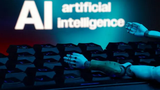 कीबोर्ड आणि रोबोटिक हातांसोबत 'एआय आर्टिफिशियल इंटेलिजन्स' असा संदेश दाखवणारं चित्र