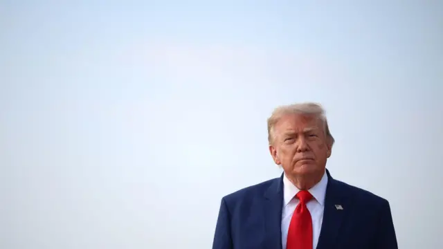 الرئيس الأمريكي دونالد ترامب ينظر إلى الصحفيين بعد نزوله من طائرة الرئاسة "إير فورس ون" في 22 يوليو/تموز 2026 في قاعدة أندروز المشتركة بولاية ميريلاند. وكان ترامب عائدًا من حضور مراسم نقل رسمية في قاعدة دوفر الجوية وتجمع انتخابي في ولاية جورجيا. 