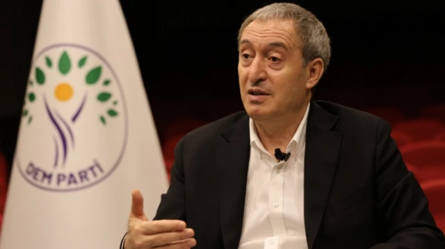 Tuncer Bakırhan konuşuyor, arkada DEM Parti flaması var
