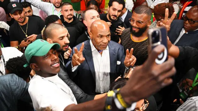 این هفته ریاض با دعوت از انبوهی از سلبریتیها نمایش پر زرق و برقی در حاشیه بوکس فیوری-انگانو راه انداخت. شما دیگر چه رویدادی را میتوانید پیدا کنید که کانر مکگرگور، قهرمان سابق دو وزن یوافسی، بین سادیو مانه، مهاجم پیشین لیورپول و بازیکن کنونی النصر و ریو فردیناند، مدافع پیشین منچستر یونایتد بنشیند؟ در این رویداد همچنین شمار زیادی از ستارههای نامدار بوکس حضور داشتند از جمله: اولکساندر اوزیک، مایک تایسون، مانی پاکیائو، ریکی هاتن، فرانک برونو، اسکار دلاهویا و شاهزاده نسیم حامد و همچنین تعدادی از ورزشکاران هنرهای رمزی ترکیبی شامل چاک لیدل، رندی کوچر، جونیور دس سانتوس و فرانک میر.