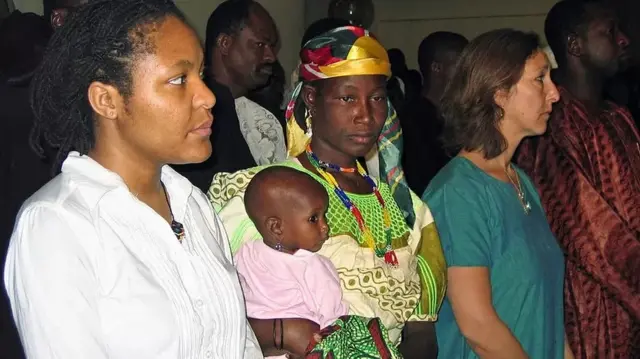 Mme Mani (portant son enfant)