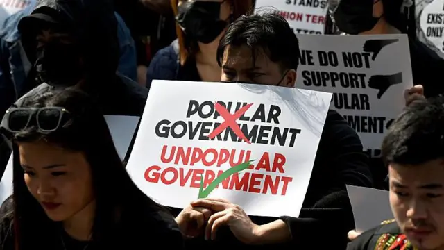 쿠키족 출신 학생 시위 참가자가 이번에 구성된 새로운 주 정부를 '인기없는 정부'라고 비난하는 플래카드를 들고 있다