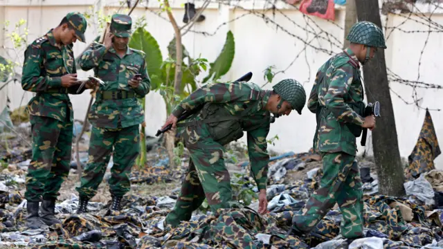 বিদ্রোহকারীদের ফেলে যাওয়া পোশাক তদারকি করছেন সেনা সদস্যরা। ছবি ২৮শে ফেব্রুয়ারি ২০০৯ 