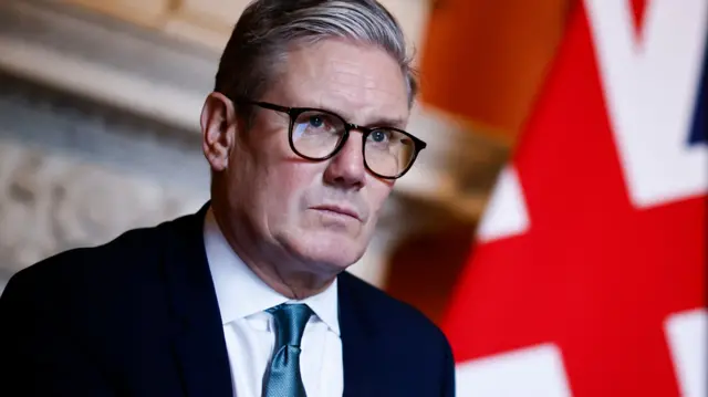 Стармер на фоне британского флага