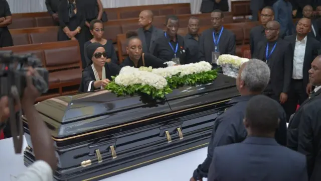 Mjane wa marehemu Reginald Mengi akiweka shada la maua juu ya jeneza