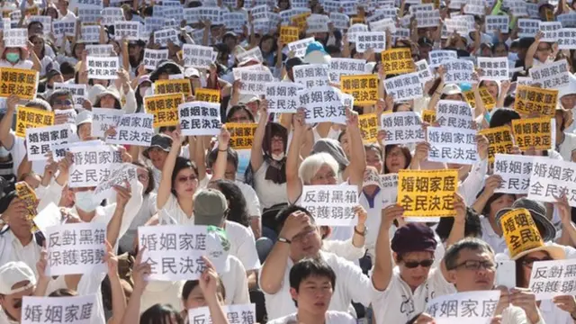 下一代幸福聯盟號召反對同性婚姻合法化的民眾身穿象徵「光明正面訴求」的白衣，手持大會發放的標語，11月17日同婚法案審理時，聚集在立法院外抗議。