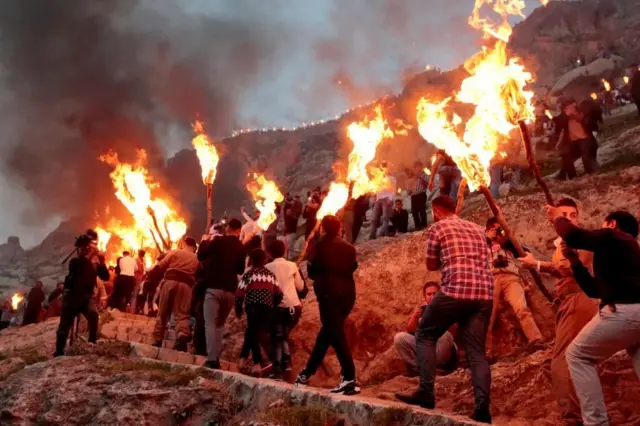 في دهوك بكردستان العراق، يحمل المئات من الشباب والشابات المشاعل ويصعدوا إلى قمة جبل عقرة (آكري) إحياء لتقليد كاوا الحداد قبل أكثر من ألفي عام. 20 مارس/آذار 2018