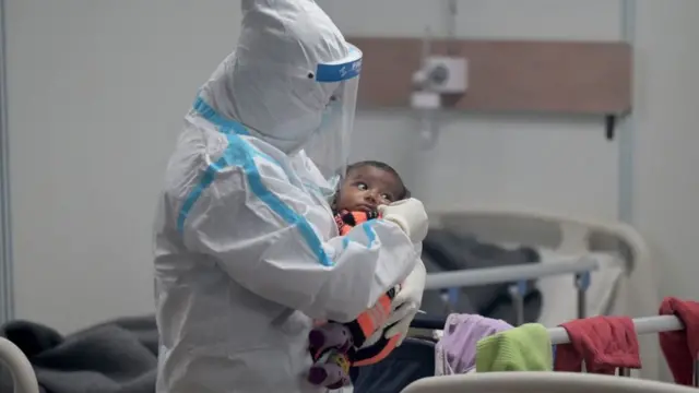 A health worker comforts a child with Covid-19