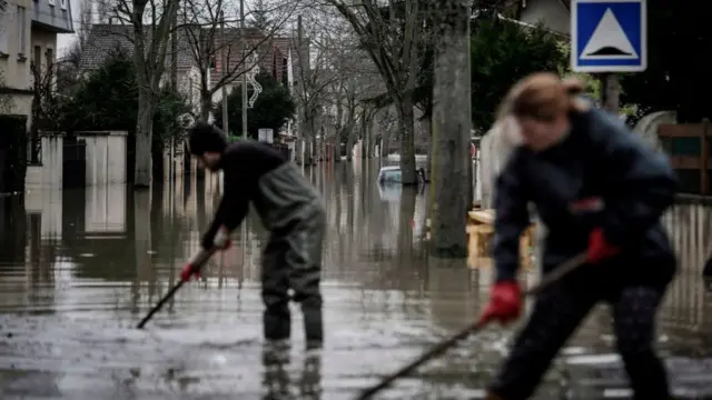 Жители расчищают от мусора улицу, превратившуюся в реку