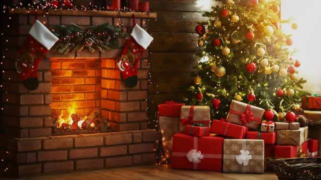 Наряженная елка с подарками у горящего камина