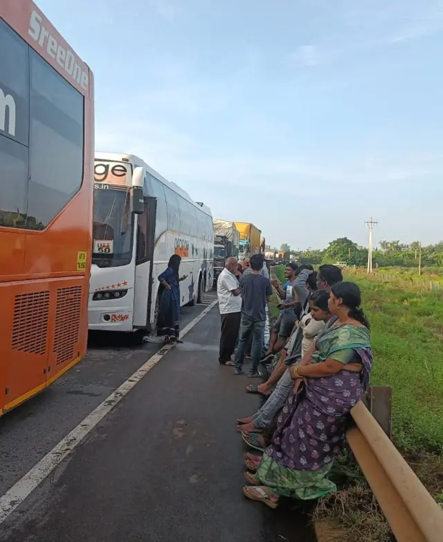 రోడ్డుకు గండిపడడంతో ఆగిపోయిన వాహనాలు, నిరీక్షిస్తున్న ప్రయాణికులు