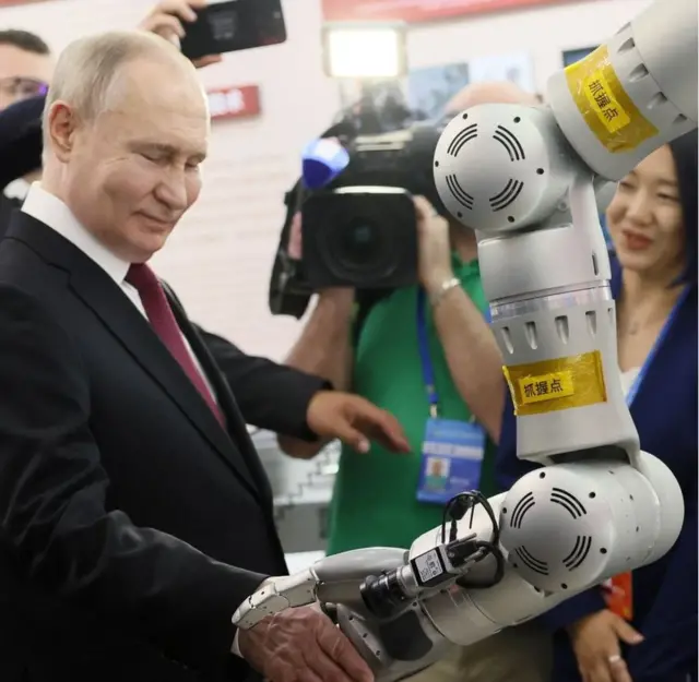 普京访问哈尔滨期间和中国制造的机器人握手。