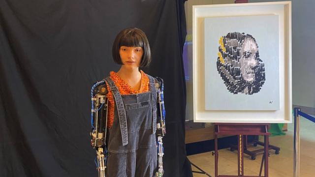 Ai-Da the robot poses with her portrait of Ada Lovelace