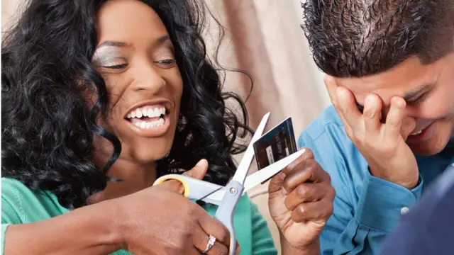 Une femme qui cisaille une carte bancaire