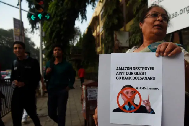 'Destruidor da Amazônia não é nosso convidado. Volte para casa, Bolsonaro', diz cartazprotestoinglês durante a visita do presidente brasileiro à Índia,janeiro2020