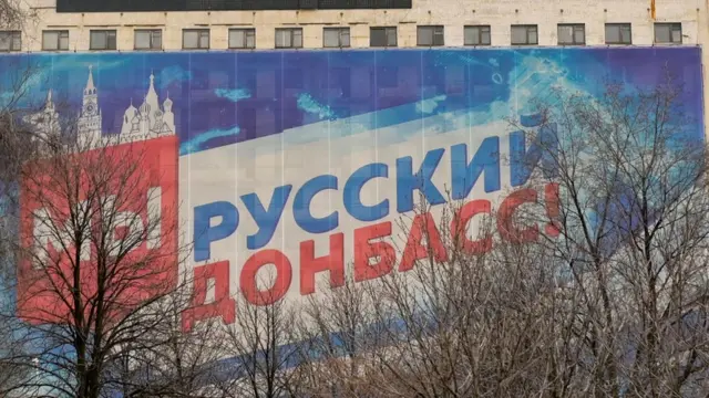 A huge banner displaying the slogan "We are Russian Donbass!" covers a building in the rebel held city of Donetsk on February 23, 2022.