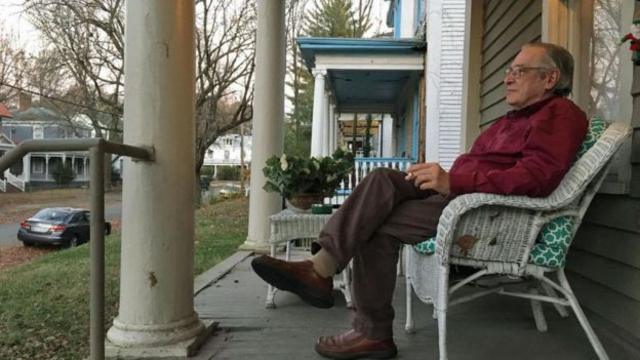 Olavo de Carvalho sentado na varanda em frente a sua casa nos EUA