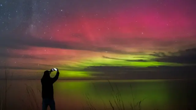 Man takes photo of aurora over Selwyn Lake, in New Zealand's Canterbury region