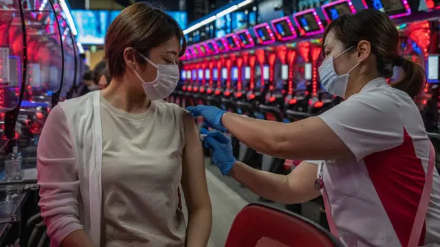 Mulher sendo vacinada por profissional da saúde dentrosportingbet funcionaum pachinko