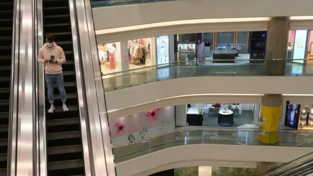 香港铜锣湾时代广场内一名男子搭扶手电梯在空无一人的购物商场内走动（21/2/2020）