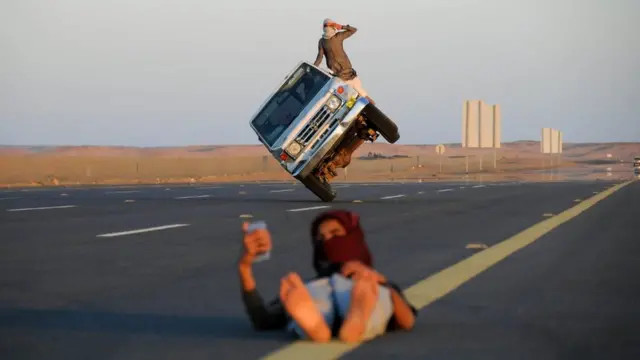 رجال سعوديون يؤدون ألعابا بهلوانية بالسيارة