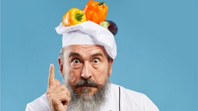 Un chef con verduras en su cabeza.
