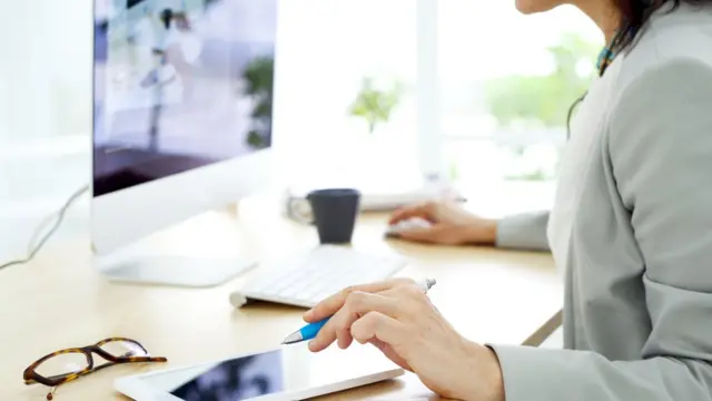 Mujer trabajando en una computadora en su casa.