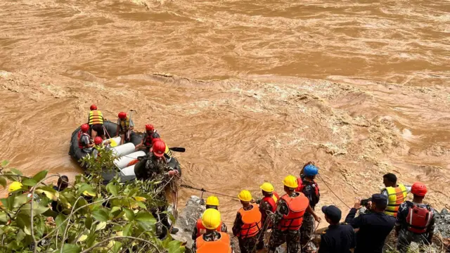 Search and rescue teams in boats look for survivors in the river after a landslide hit two passenger buses in Chitwan, Nepal.