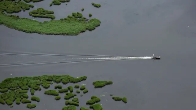 Una embarcación cruza el lago Borgne