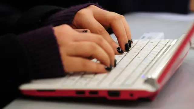 కంప్యూటర్ పై టైప్ చేస్తున్న మహిళ