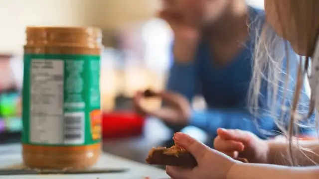 Niña comiendo mantequilla de maní