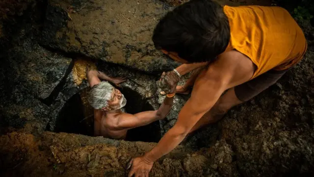 Mfanyakazi akisaidiwa kutoka shimoni