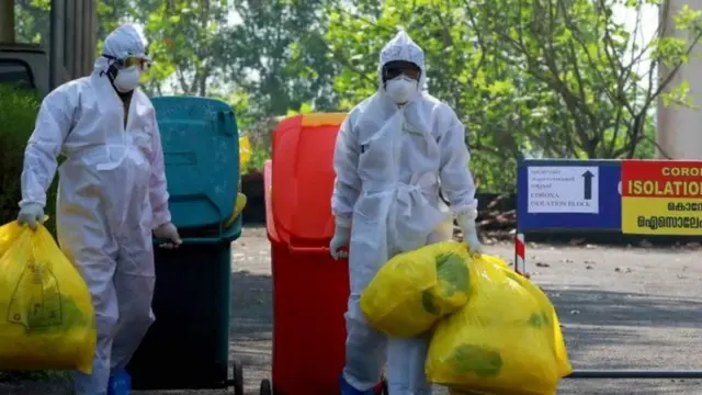 બે સફાઈકર્મીઓ પીપીઈ કિટ પહેરેલા