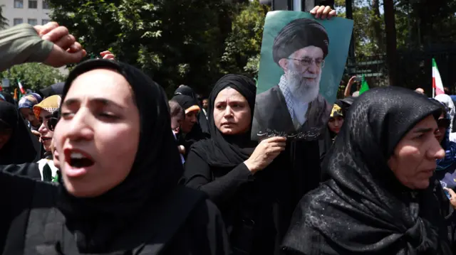 Mujeres en una protesta en Teherán contra Israel, una de ellas porta una imagen del líder supremo de Irán, Alí Jamenei