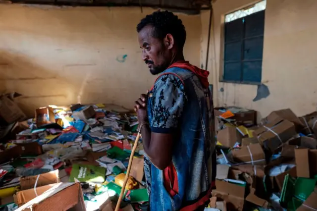 A man stands in the library of an elementary school that was damaged during the fightings that broke out in Ethiopia's Tigray region, in the village of Bisober, on December 9, 2020.