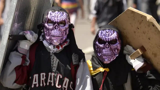 Dos manifestantes con máscaras