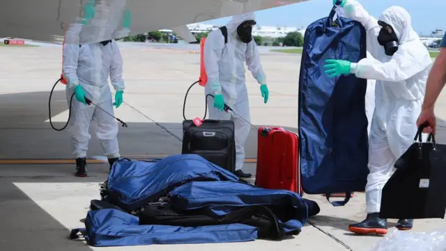 เจ้าหน้าที่่พ่นน้ำยาฆ่าเชื้อที่สัมภาระของคณะ ผบ.ทบ.สหรัฐฯ