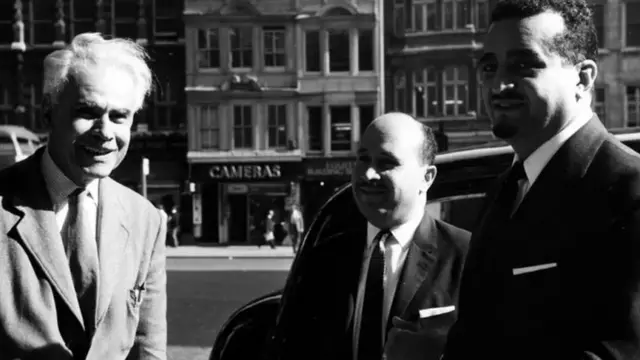 الأمير فهد بن عبدالعزيز، وزير الداخلية السعودي في زيارة لمقر بي بي سي العربية في بوش هاوس في عام 1964، ويظهر في يسار الصورة الاذاعي حسن الكرمي