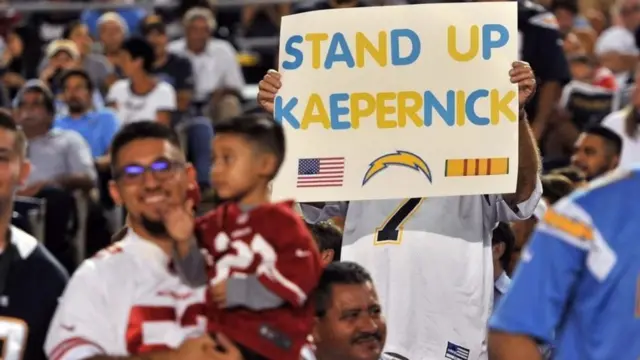 Cartel en el que se lee "Ponte de pie, Kaepernick".