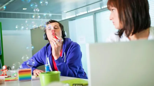 Un empleado hace burbujas de jabón en la oficina