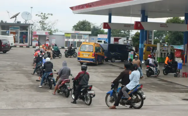 Ilustrasi pesepeda motor mengantre untuk mengisi bensin di SPBU Pertamina.