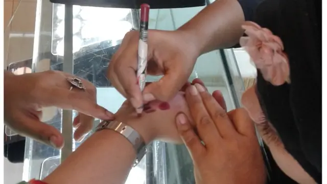 হাতে মেহেদি দেয়া হচ্ছে।