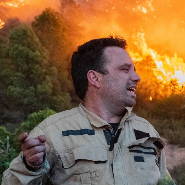 Marc Castellnou con un bosque en llamas de fondo